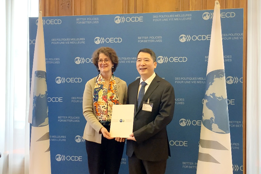 Bà Josée Fecteau, Trưởng Ban Pháp chế OECD trao bản sao chứng thực Hiệp định MAAC cho Thứ trưởng Bộ Tài chính Cao Anh Tuấn.