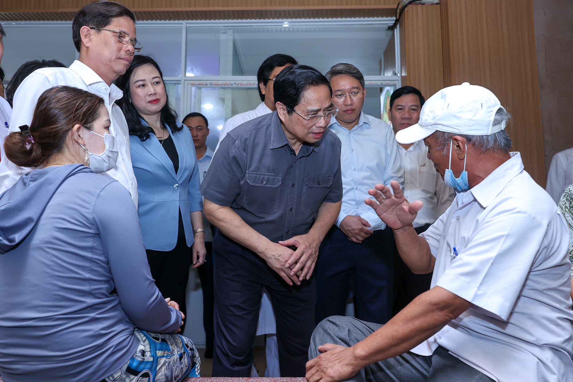 Thủ tướng lắng nghe người nhà bệnh nhân chia sẻ về công tác khám, chữa bệnh tại Bệnh viện - Ảnh: VGP