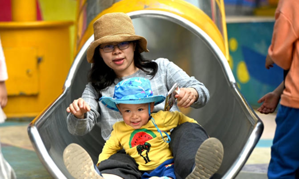 Một bà mẹ và con chơi cầu trượt tại khu mua sắm Wukesong ở Bắc Kinh - Ảnh: Getty Images
