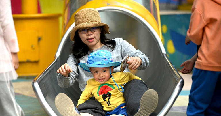Một bà mẹ và con chơi cầu trượt tại khu mua sắm Wukesong ở Bắc Kinh - Ảnh: Getty Images