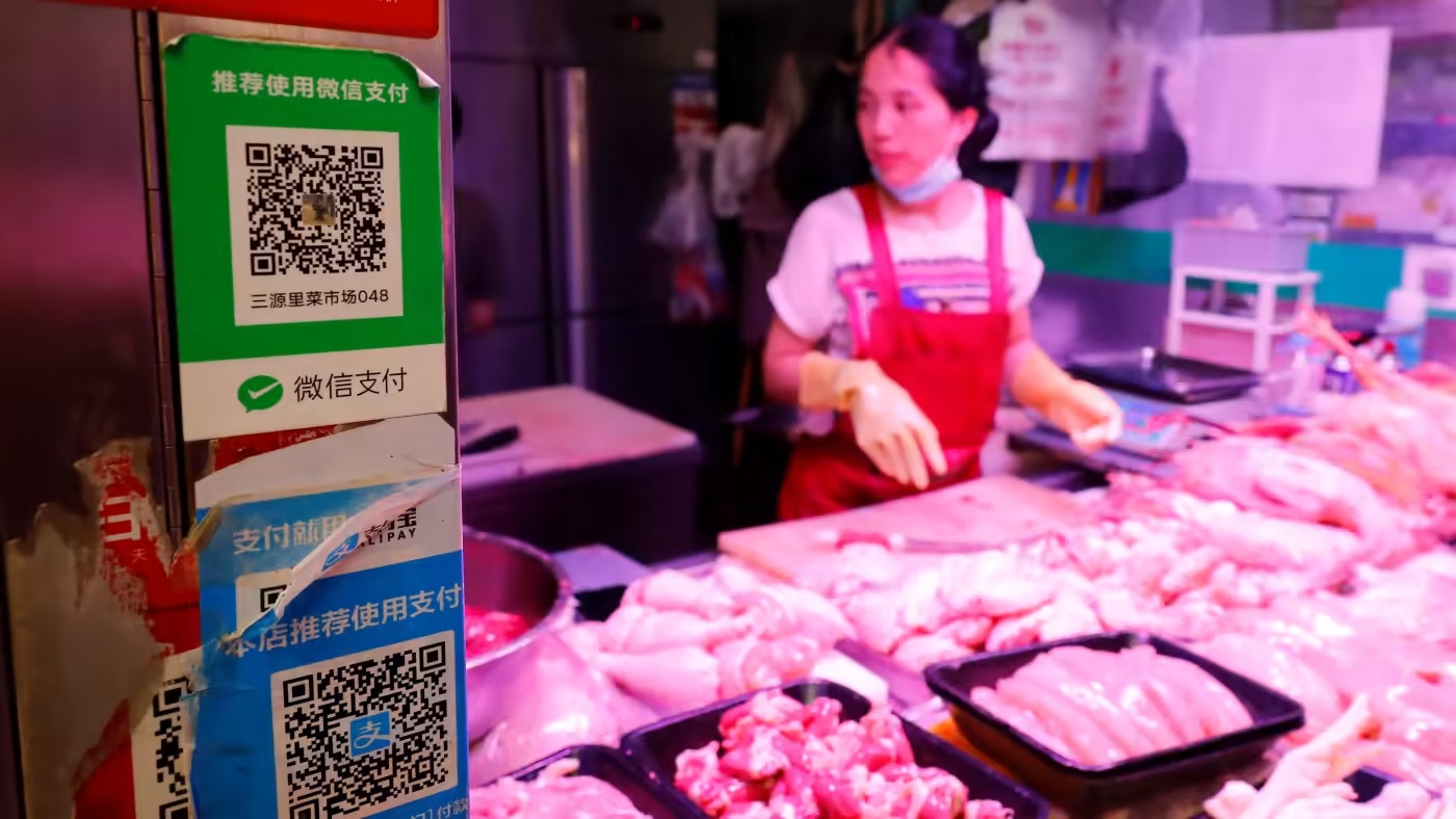 Một quầy thịt ở Bắc Kinh chấp nhận thanh toán không dùng tiền mặt thông qua việc sử dụng mã QR. Trung Quốc là quốc gia ít phụ thuộc vào tiền mặt nhất ở châu Á vào năm 2022. Ảnh: Reuters