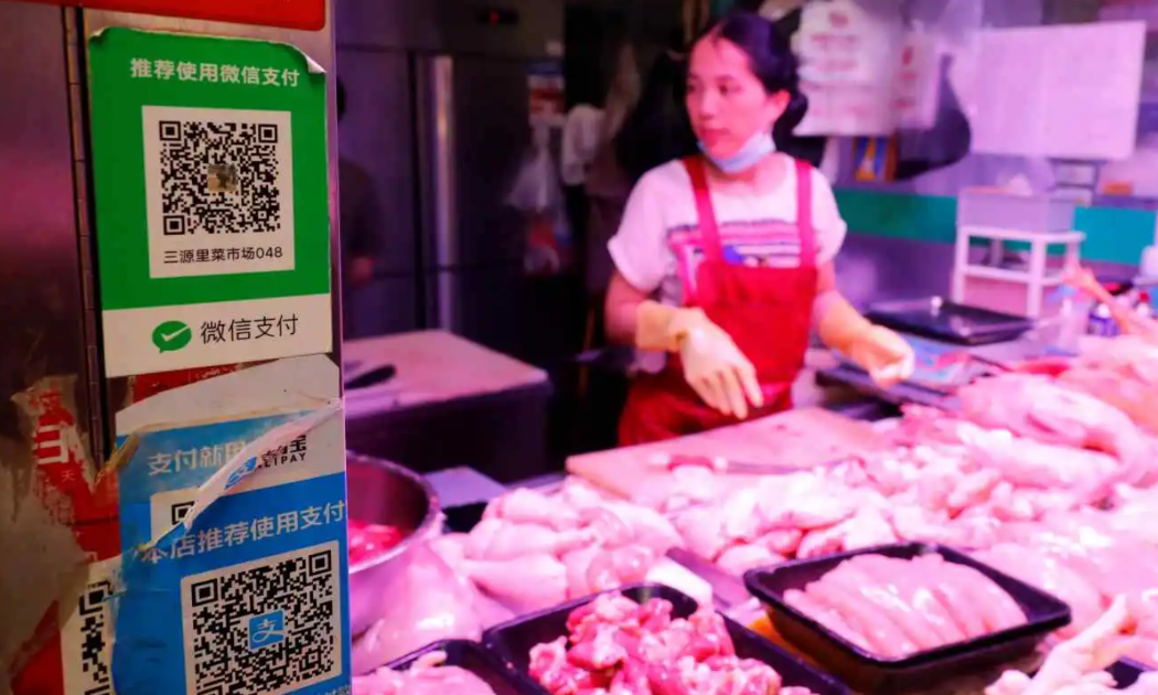 Một quầy thịt ở Bắc Kinh chấp nhận thanh toán không tiền mặt qua việc mã QR. Trung Quốc là quốc gia ít phụ thuộc vào tiền mặt nhất ở châu Á trong năm 2022 - Ảnh: Reuters