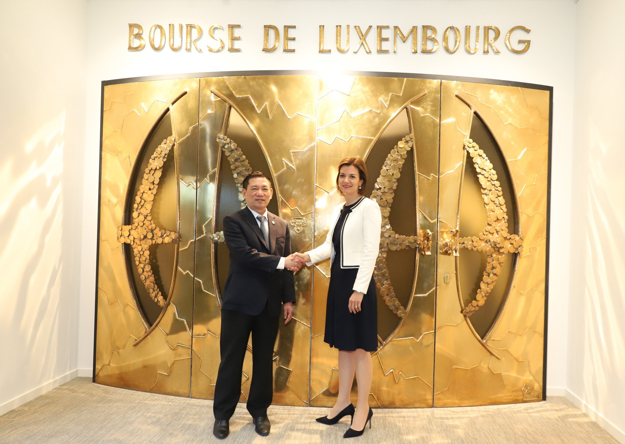 Bộ trưởng Hồ Đức Phớc bắt tay với bà Julie Becker - Tổng Giám đốc Sở Giao dịch chứng khoán Luxembourg. 