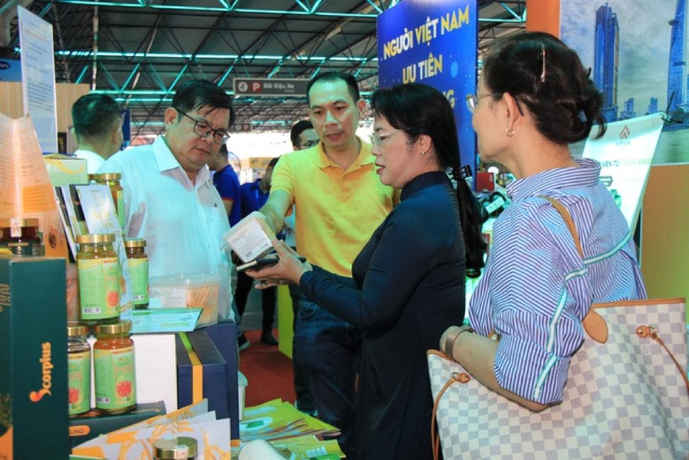 Bà Trần Kim Yến (áo dài tím than), Phó Trưởng Ban Thường trực Ban Chỉ đạo tại gian hàng sản phẩm Việt.