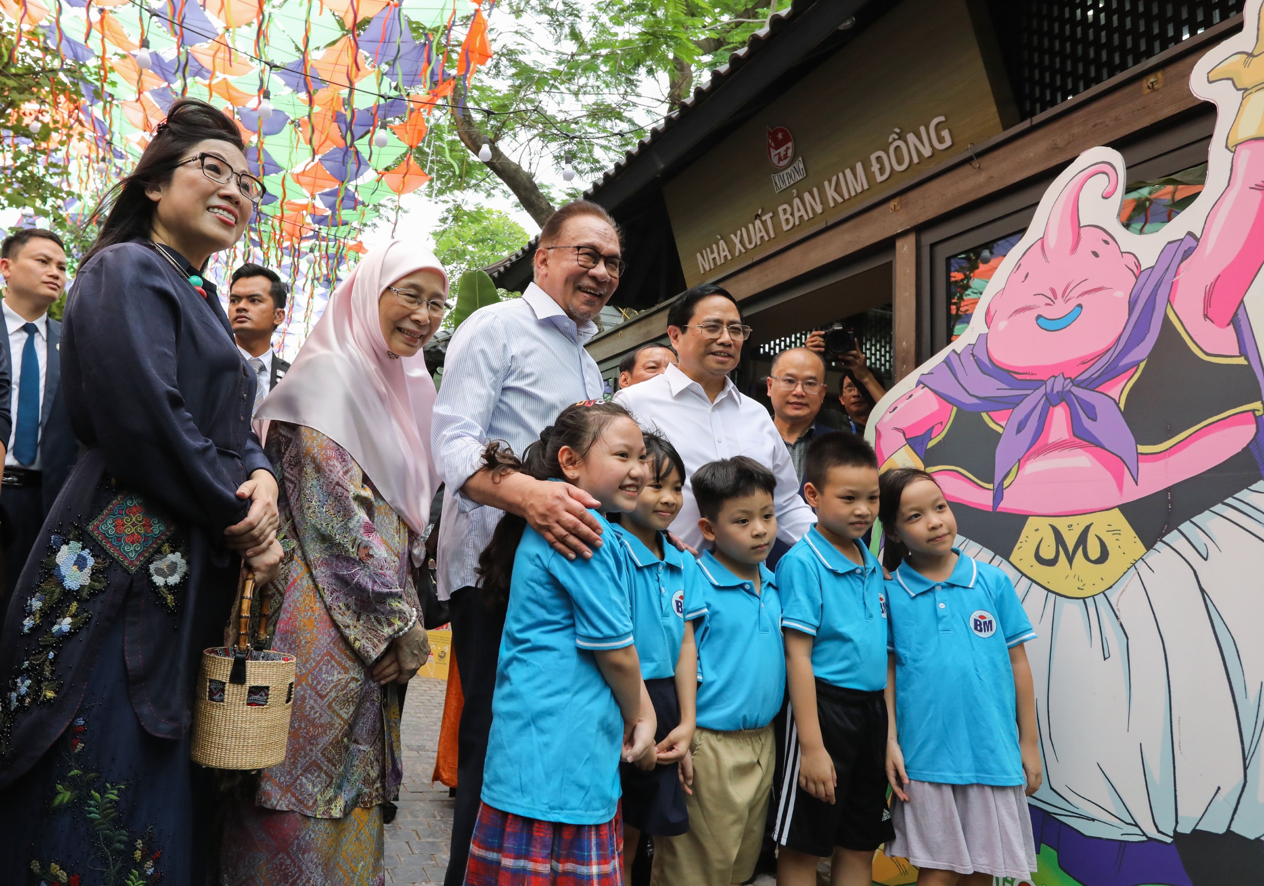 Thủ tướng Phạm Minh Chính và Thủ tướng Anwar Ibrahim cùng hai Phu nhân chụp ảnh lưu niệm cùng các cháu thiếu nhi tại phố sách. Ảnh: Trí Phong.