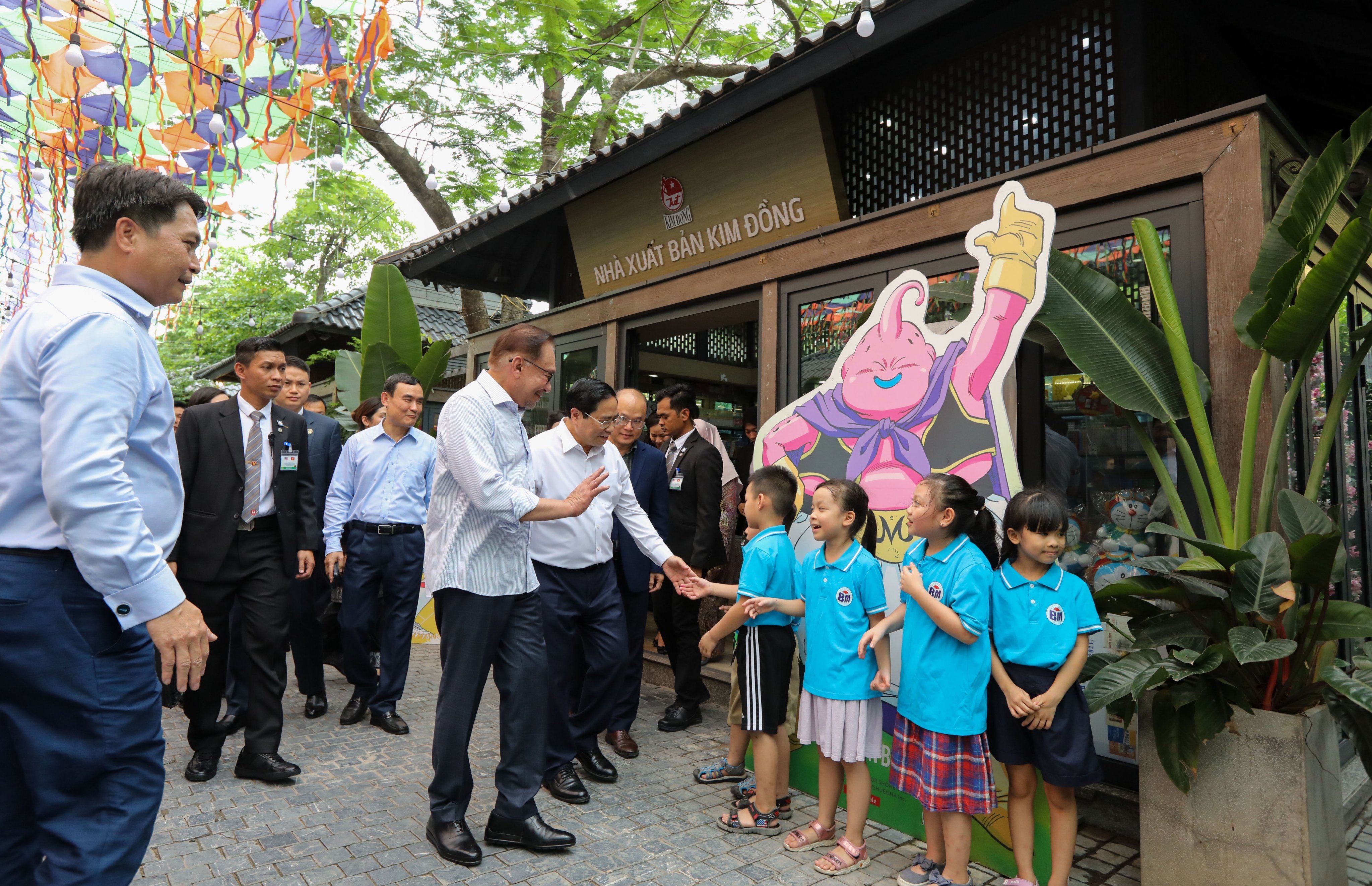 Thủ tướng Phạm Minh Ch&iacute;nh v&agrave; Thủ tướng Anwar Ibrahim tr&ograve; chuyện với c&aacute;c bạn nhỏ tại phố s&aacute;ch. Ảnh: Tr&iacute; Phong.