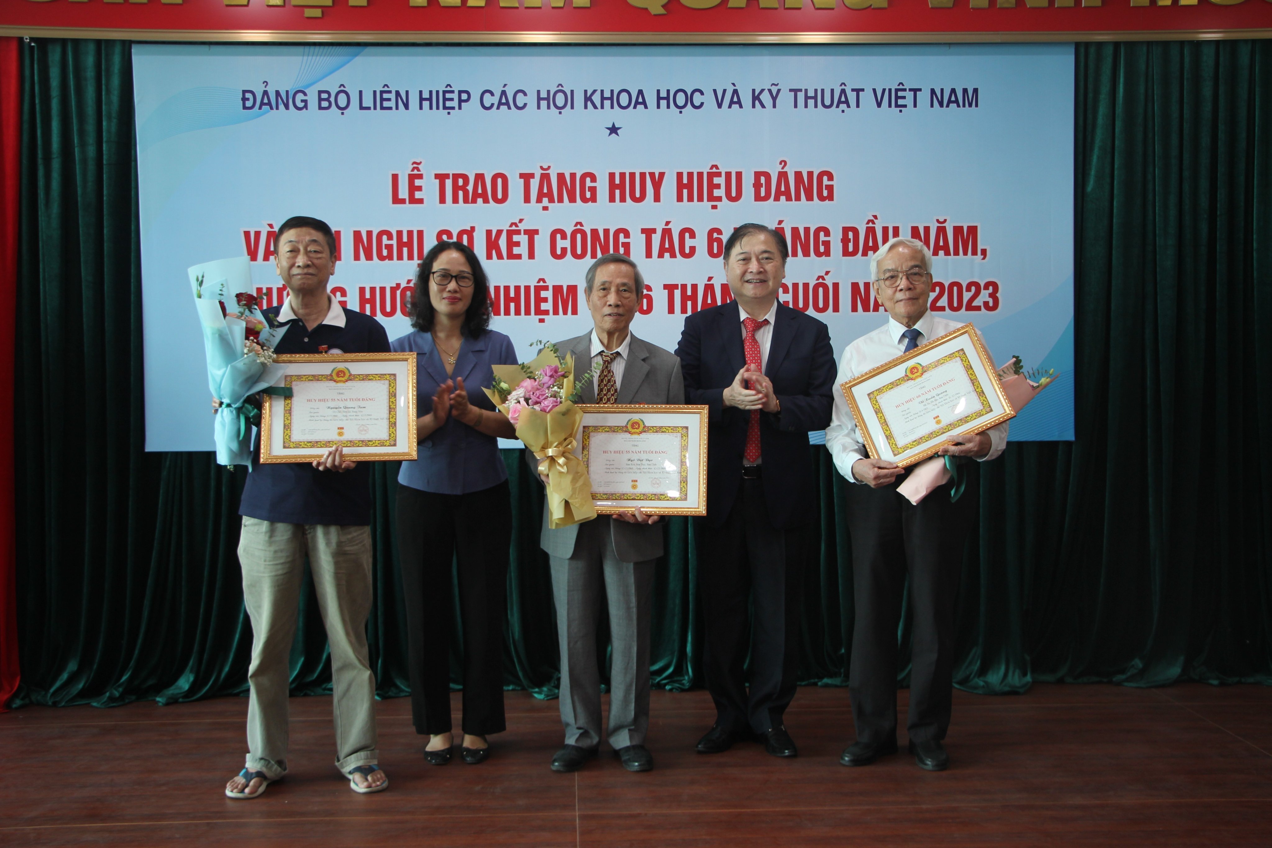 TSKH Phan Xuân Dũng, Bí thư Đảng Đoàn, Chủ tịch VUSTA và bà Hà Thị Trang, Uỷ viên Ban Thường vụ, Trưởng Ban Dân vận Đảng ủy Khối các cơ quan Trung ương,  trao huy hiệu Đảng cho các đảng viên.