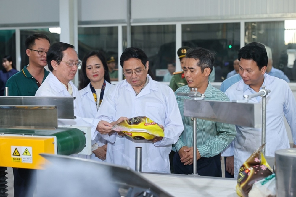 Thủ tướng xem sản phẩm xuất khẩu của nhà máy chế biến gạo của Công ty VINARICE. Ảnh: VGP.