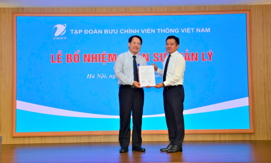 Ông Huỳnh Quang Liêm Tổng giám đốc Tập đoàn VNPT trao quyết định bổ nhiệm cho ông Nguyễn Văn Tấn (bên trái).