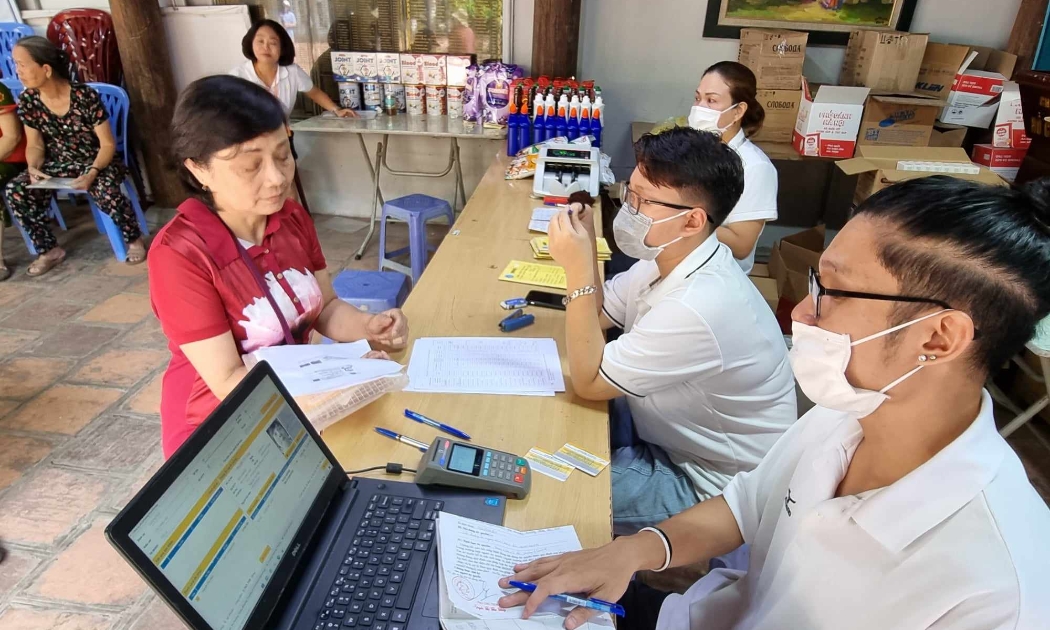 Cán bộ bưu điện chi trả lương hưu cho người lao động. Ảnh - Xuân Minh. 