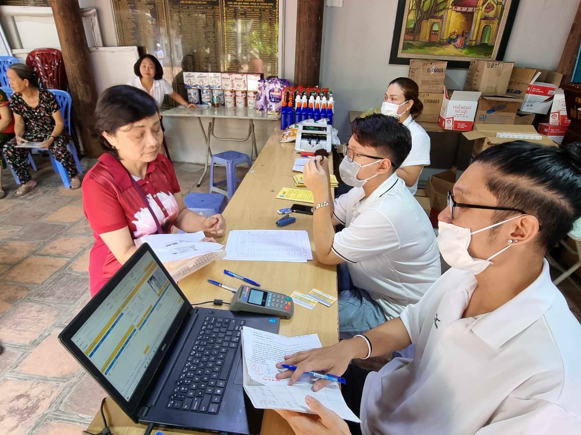 Cán bộ bưu điện chi trả lương hưu cho người lao động. Ảnh - Xuân Minh. 