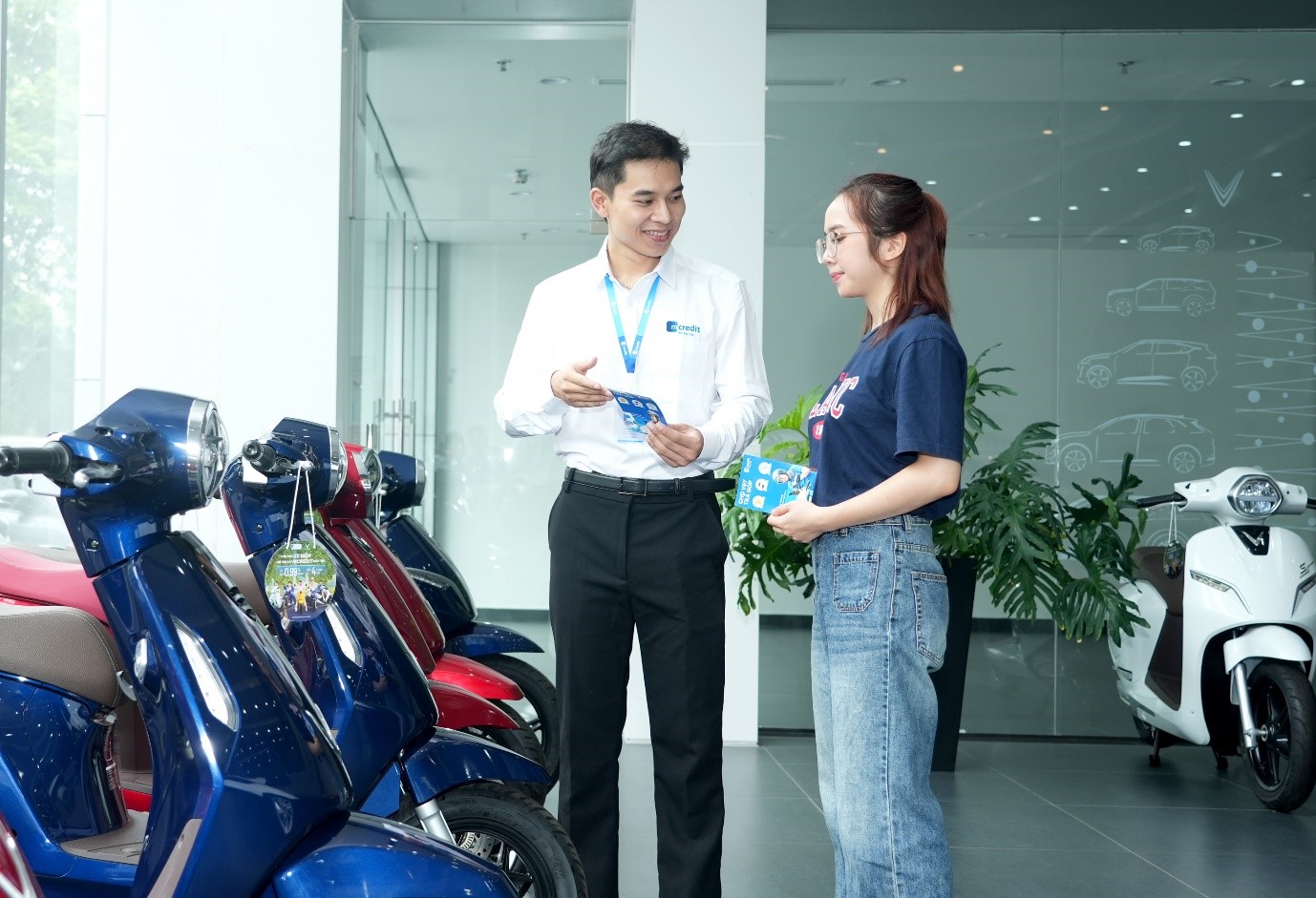 Nh&acirc;n vi&ecirc;n Mcredit tư v&acirc;́n khách hàng mua xe máy đi&ecirc;̣n VinFast trả góp tại showroom.