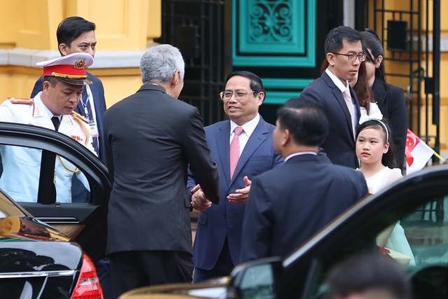 Thủ tướng Phạm Minh Chính đón Thủ tướng Singapore Lý Hiển Long tại xe - Ảnh: VGP/Nhật Bắc.