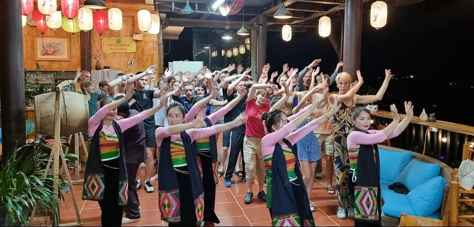 Kh&aacute;ch du lịch quốc tế h&agrave;o hứng h&ograve;a m&igrave;nh v&agrave;o những điệu m&uacute;a truyền thống của đồng b&agrave;o Th&aacute;i tại P&ugrave; Lu&ocirc;ng, huyện B&aacute; Thước