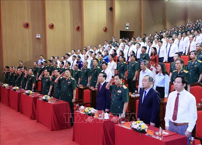 Chủ tịch nước cùng các đại biểu thực hiện nghi lễ chào cờ. Ảnh: TTXVN