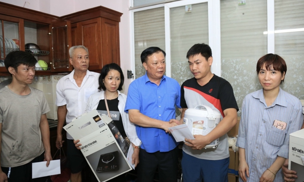 Bí thư Thành ủy Hà Nội Đinh Tiến Dũng trao quà hỗ trợ cho các nạn nhân vụ cháy chung cư mini tại phường Khương Đình. Ảnh: TTXVN