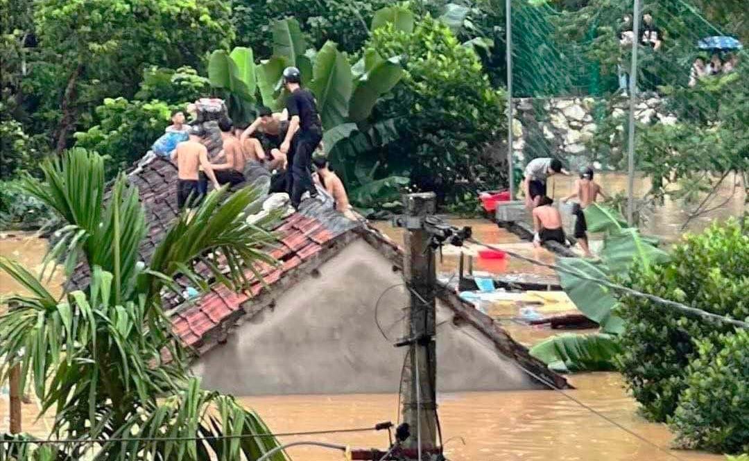 40 học sinh phá mái ngói, trèo lên nóc nhà sau đó men theo tường rào của trường để đến chỗ cao tránh cơn lũ lên quá nhanh. Ảnh: Thành Đạt