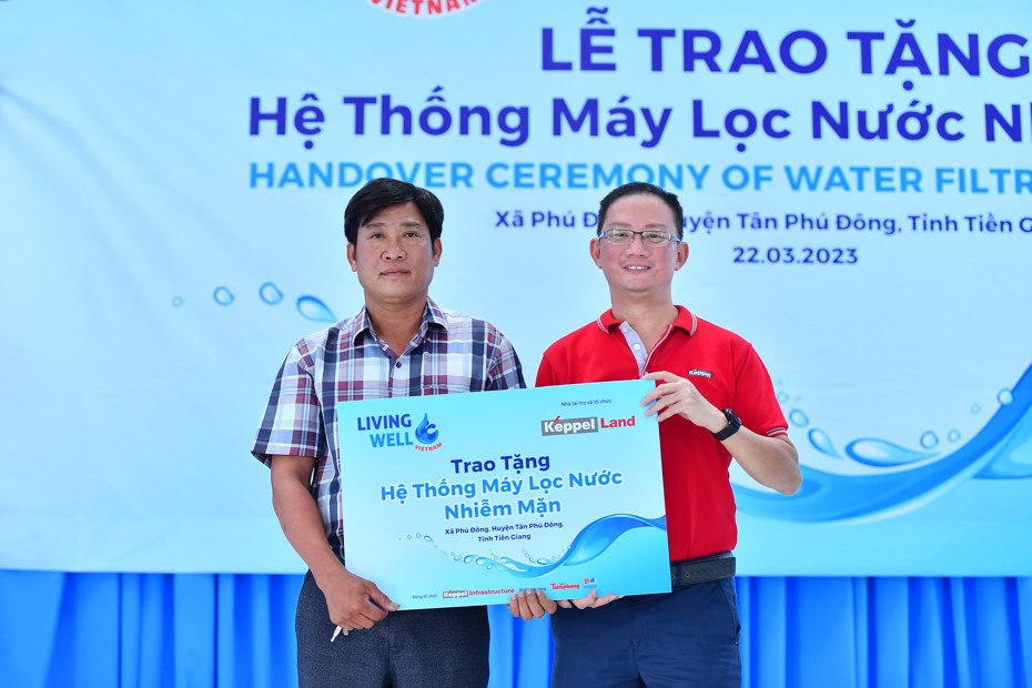 Ông Joseph Low (phải), Chủ tịch mảng Bất động sản, Tập đoàn Keppel tại Việt Nam và đại diện lãnh đạo UBND xã Phú Đông, huyện Tân Phú Đông, tỉnh Tiền Giang tại buổi lễ trao tặng hệ thống máy lọc nước nhiễm mặn Living Well tại tỉnh Tiền Giang.