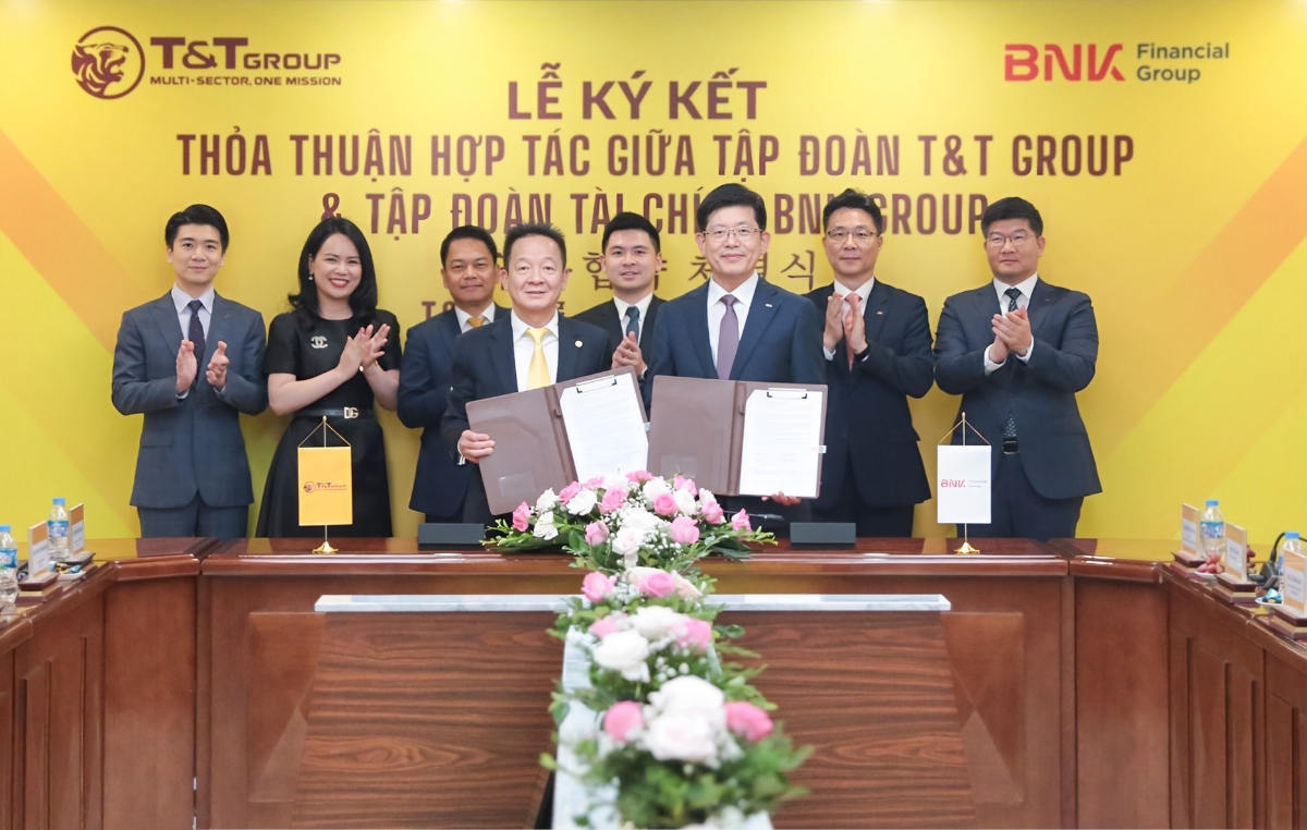 Ông Đỗ Quang Hiển, Chủ tịch UBCL Tập đoàn T&T Group (bên trái) và ông Bin Dae-in, Chủ tịch HĐQT kiêm Tổng giám đốc Tập đoàn Tài chính BNK (bên phải) trao thỏa thuận hợp tác với sự chứng kiến của đại diện lãnh đạo hai Tập đoàn.
