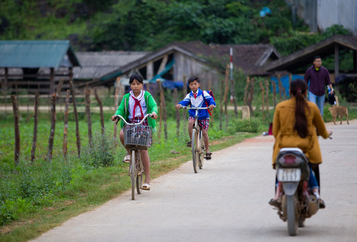 Trẻ em trong l&agrave;ng đạp xe đi học v&agrave;o s&aacute;ng sớm