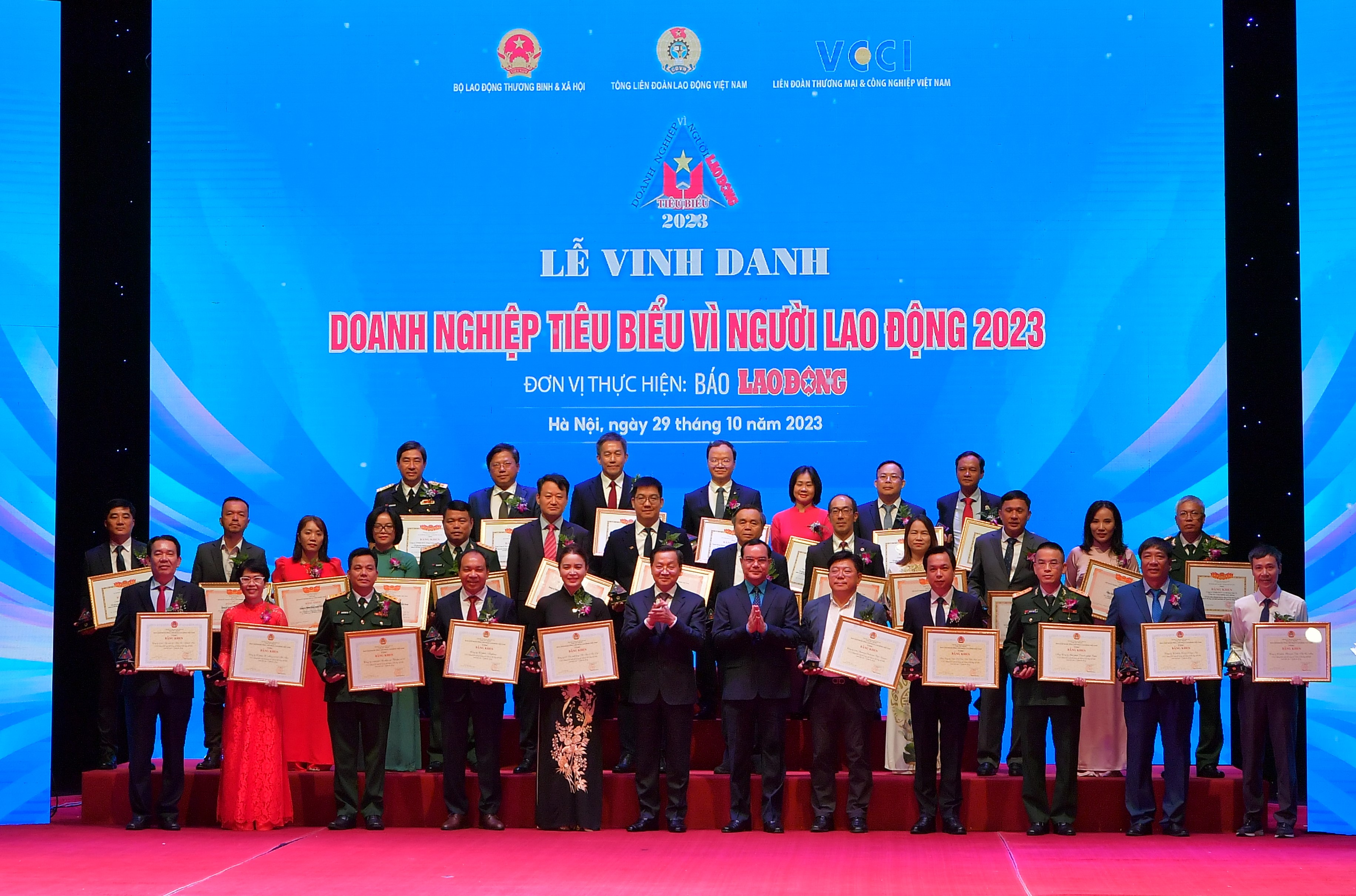 Phó Thủ tướng Lê Minh Khái (hàng đầu, thứ 6 từ trái sang) và Chủ tịch Tổng Liên đoàn Lao động Việt Nam Nguyễn Đình Khang (hàng đầu, thứ 6 từ phải sang) chụp ảnh kỷ niệm cùng đ/c Lê Quang Vinh - Phó Tổng Giám đốc Vietcombank (hàng 3, thứ 4 từ phải sang) và 29 doanh nghiệp khác được nhận Bằng khen “Doanh nghiệp tiêu biểu vì người lao động”.