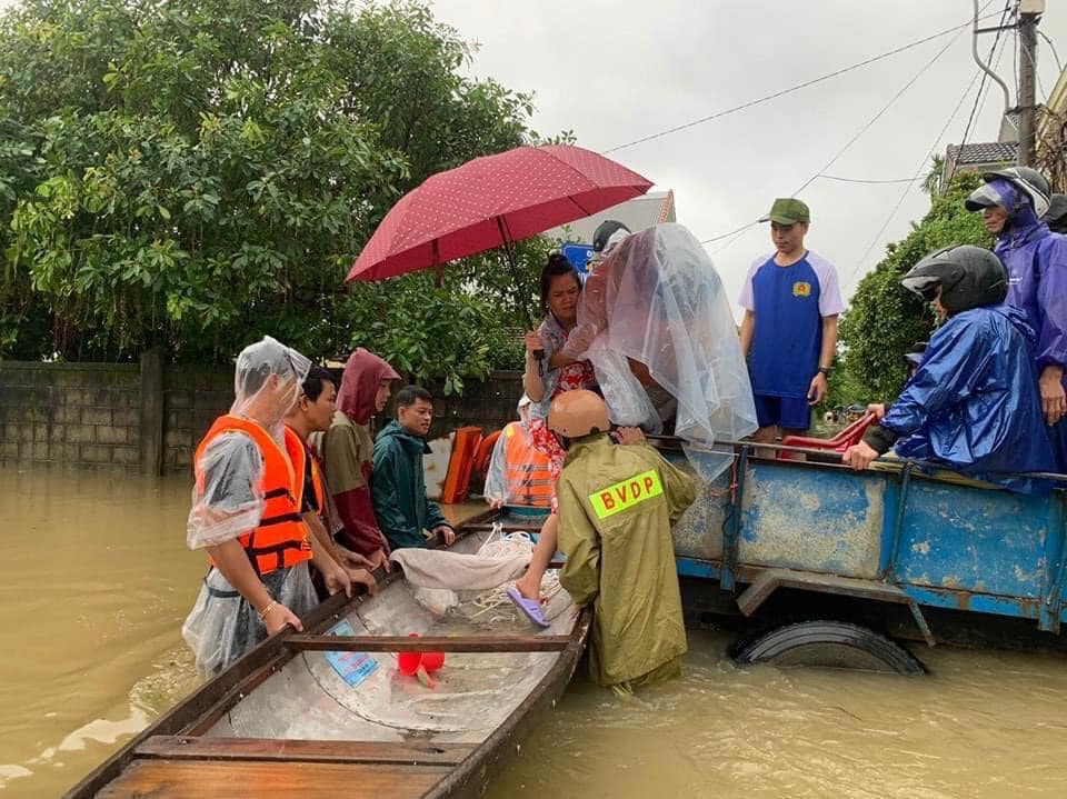 Các chiến sĩ Công an Thừa Thiên Huế đưa thai phụ lên ghe vượt lũ đến bệnh viện.