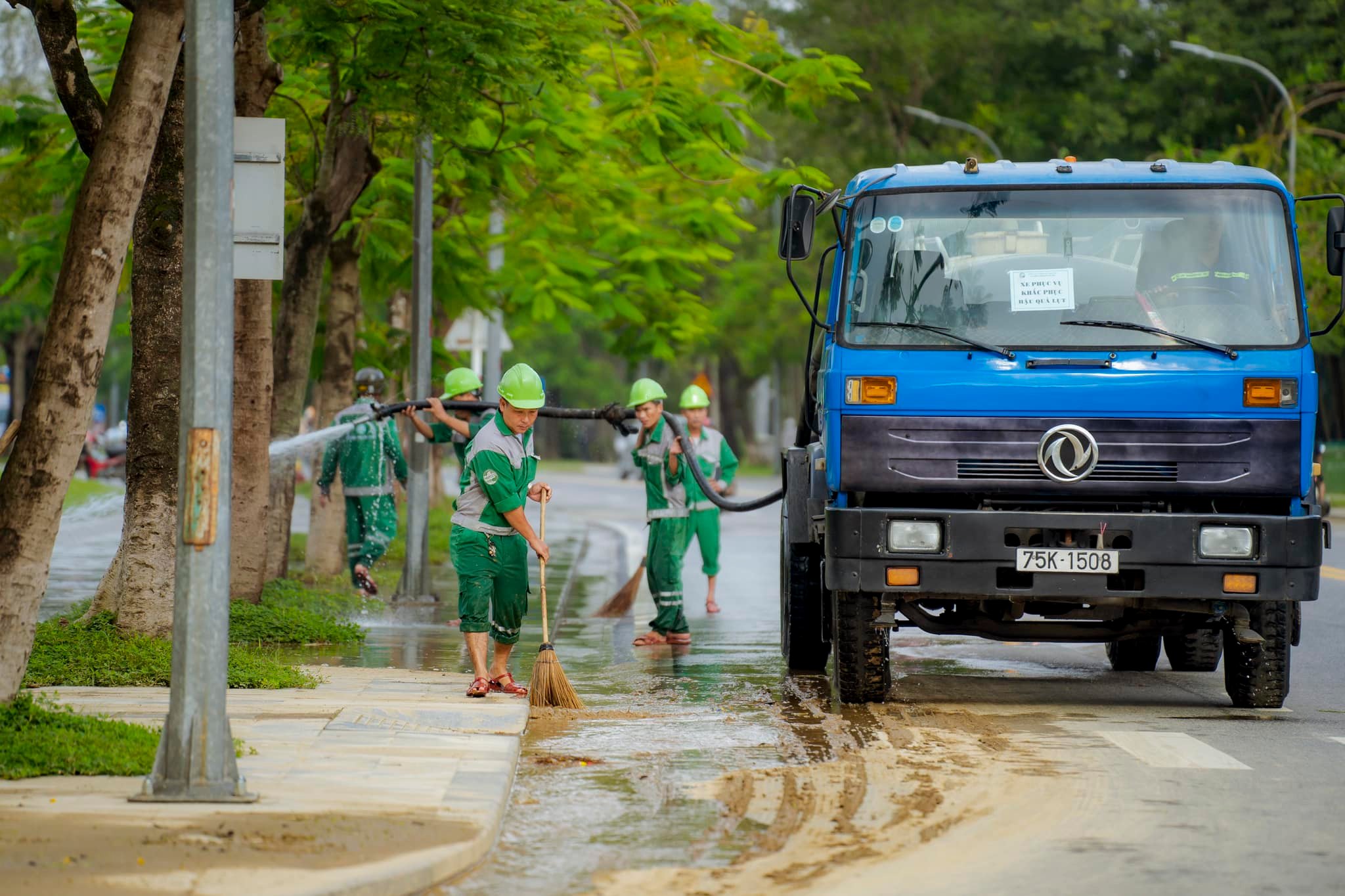 Các công nhân vệ sinh môi trường dọn dẹp bùn đất trên các tuyến đường phố Huế.