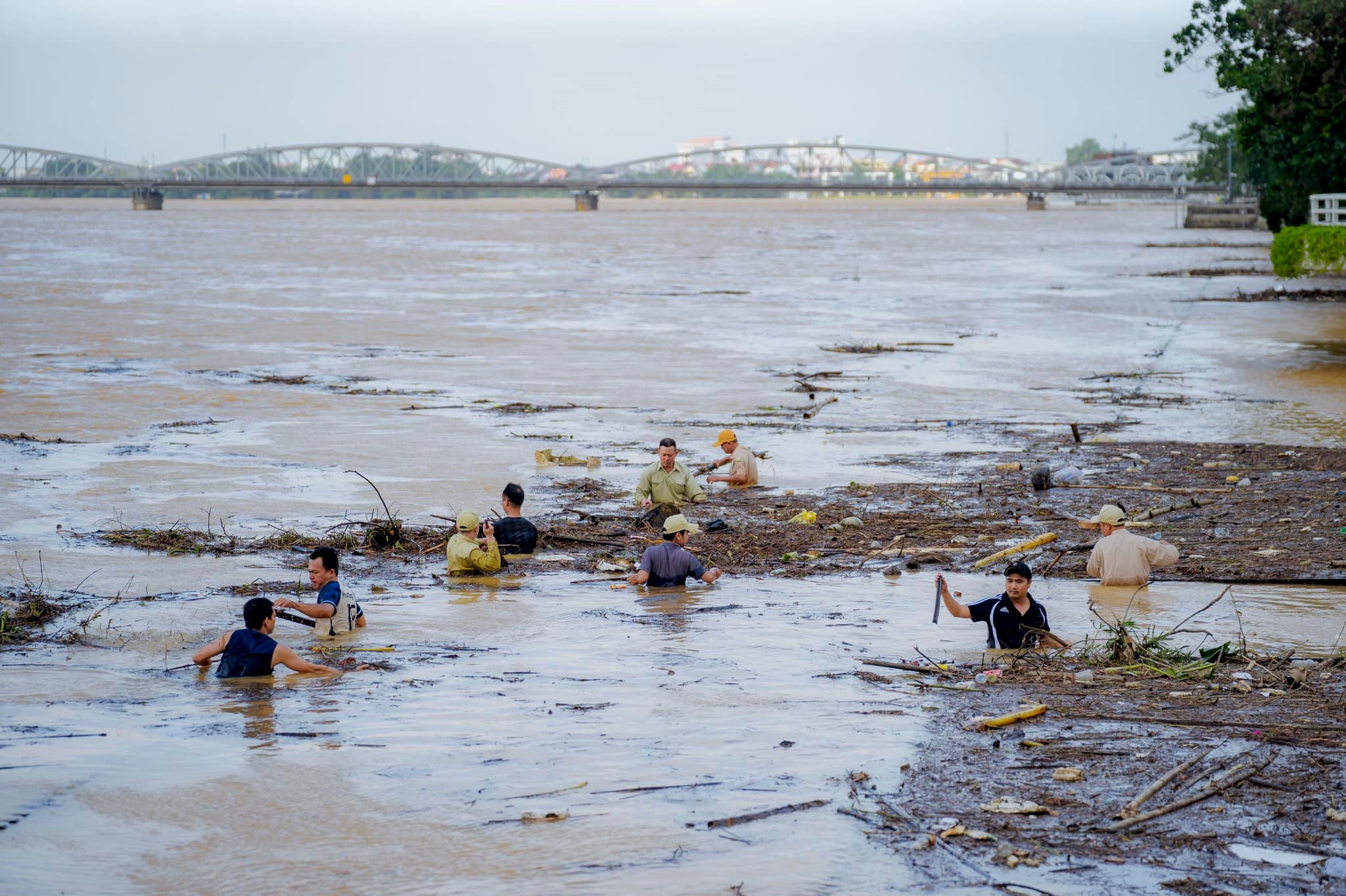 Người d&acirc;n tập trung dọn r&aacute;c thải &ugrave;n ứ tr&ecirc;n s&ocirc;ng Hương khi nước lũ hạ dần.