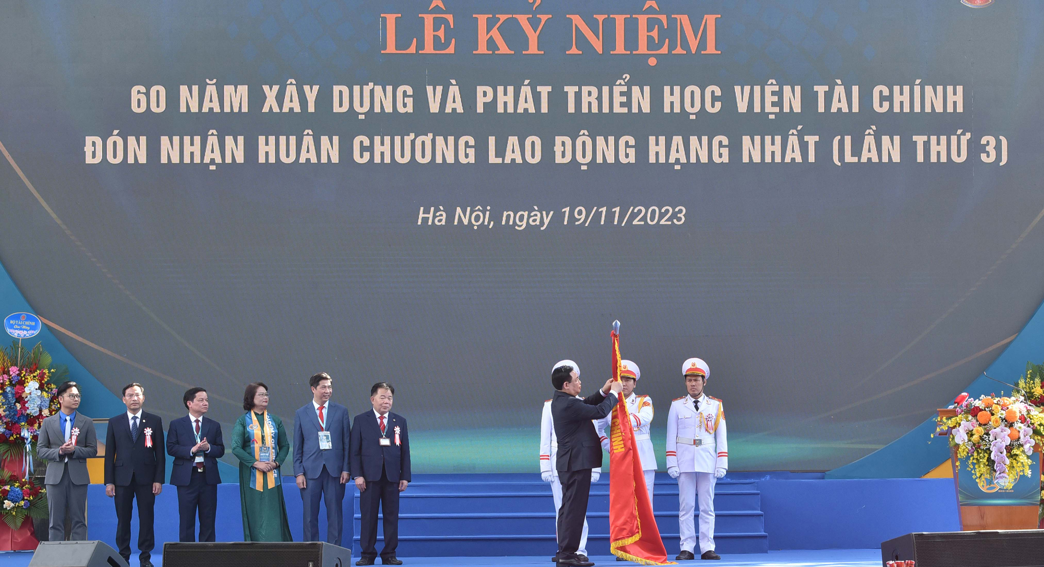 Chủ tịch Quốc hội Vương Đình Huệ gắn Huân chương Lao động hạng Nhất lần thứ 3 lên Lá cờ truyền thống của Học viện Tài chính. Ảnh: ĐBND.