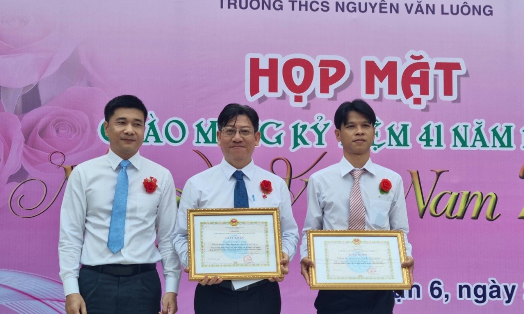 Phó Giám đốc Bảo hiểm xã hội TP.HCM Trần Dũng Hà trao tặng Giấy khen tới tập thể Trường THCS Nguyễn Văn Luông, thầy giáo Đinh Phú Cường - Hiệu trưởng nhà trường. Ảnh - BHXH Việt Nam.