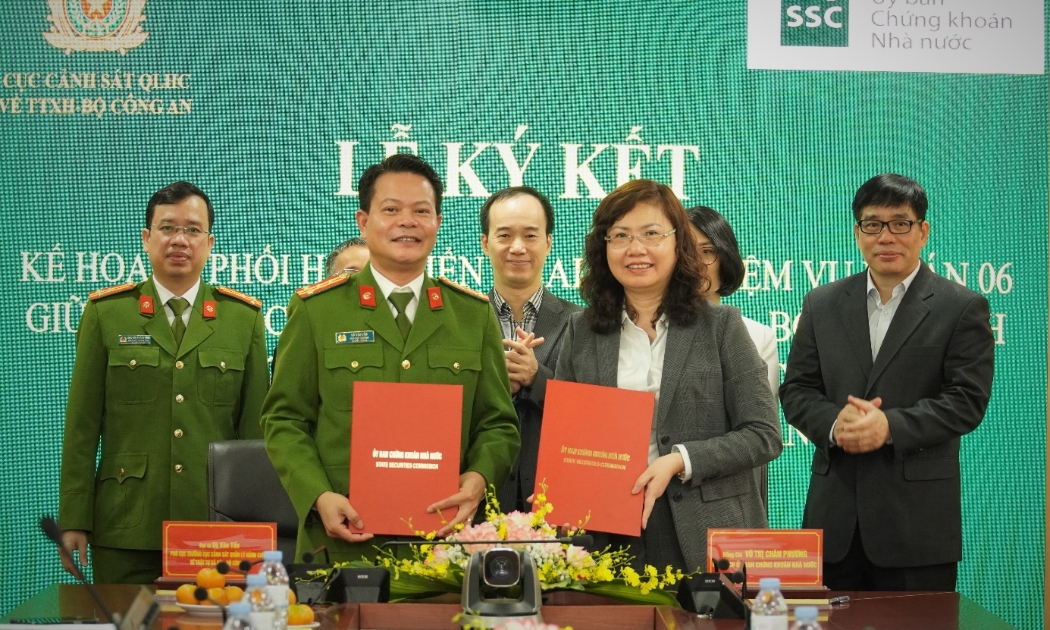  Chủ tịch Ủy ban Chứng khoán Nhà nước Vũ Thị Chân Phương và Đại tá Vũ Văn Tấn, Phó Cục trưởng Cục Cảnh sát Quản lý hành chính về trật tự xã hội (Bộ Công an) trao biên bản ký kết.