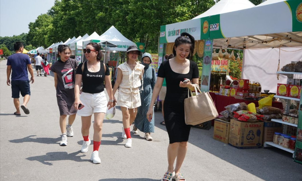 Người dân thành phố Thanh Hóa đi mua sắm tại hội chợ thương mại diễn ra tại Công viên Hội An