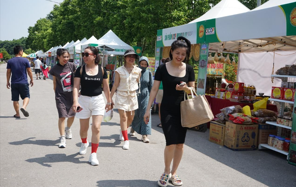 Người dân thành phố Thanh Hóa đi mua sắm tại hội chợ thương mại diễn ra tại Công viên Hội An