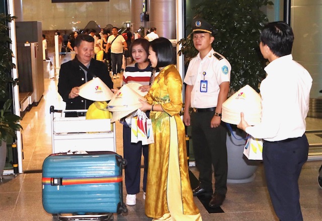 Tặng quà lưu niệm cho hành khách trên chuyến bay mang số hiệu 5J 57 đến sân bay quốc tế Đà Nẵng lúc 21h ngày 7/12. Ảnh: Ngô Anh Văn.