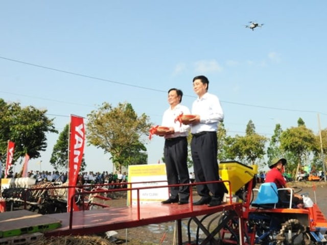 Bộ trưởng L&ecirc; Minh Hoan v&agrave; &ocirc;ng Cao Đức Ph&aacute;t c&ugrave;ng điều khiển m&aacute;y gieo sạ tr&ecirc;n c&aacute;nh đồng.&nbsp;