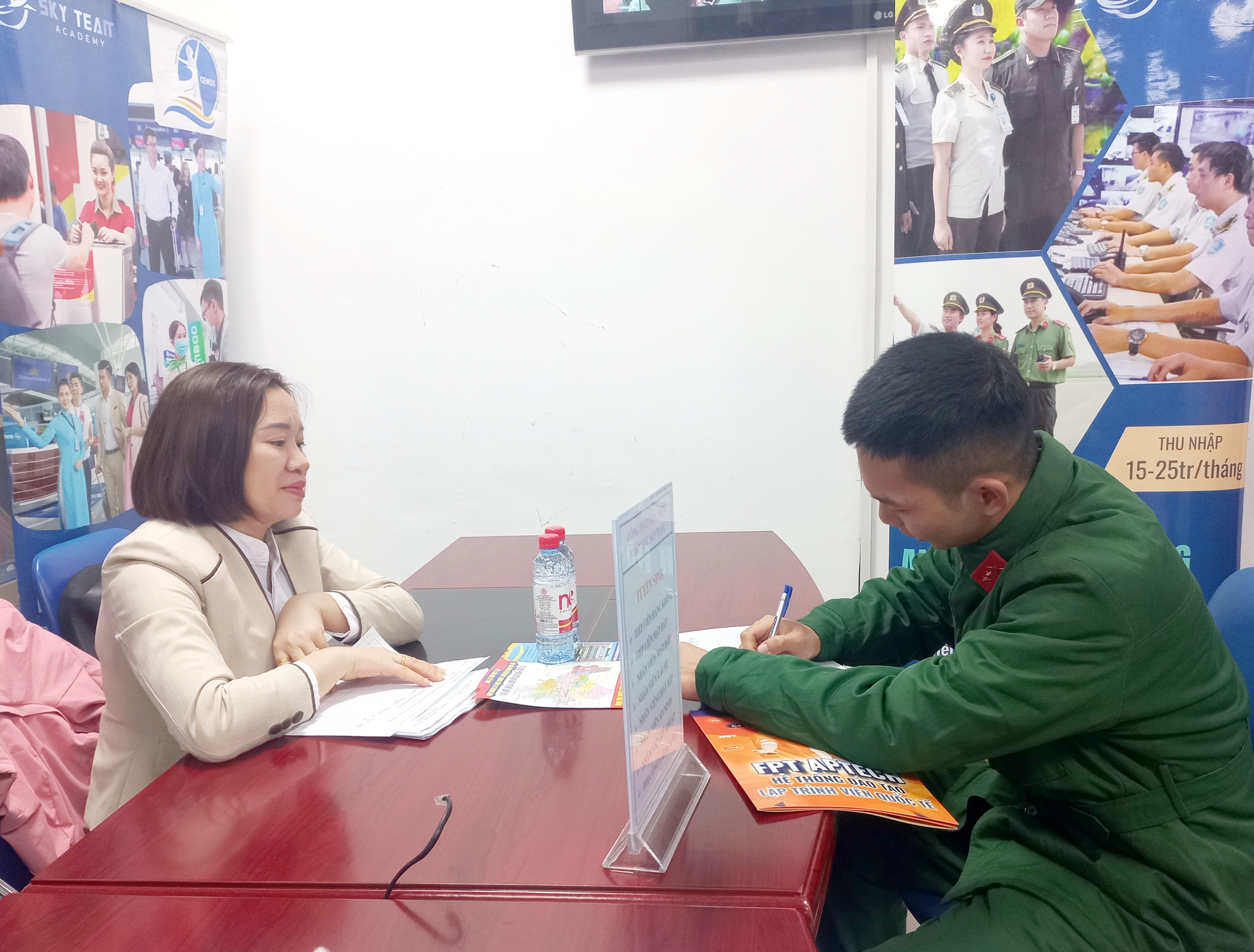 Bà Phạm Thị Mận (bên trái), Giám đốc tuyển sinh của Học viện Sky Team trao đổi với ứng viên. Ảnh - Nhật Dương.
