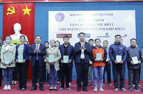 Tổng Giám đốc Nguyễn Thế Mạnh và đại diện Ủy ban nhân dân huyện Mai Châu trao tặng món quà cho người dân. Ảnh - BHXH Việt Nam.