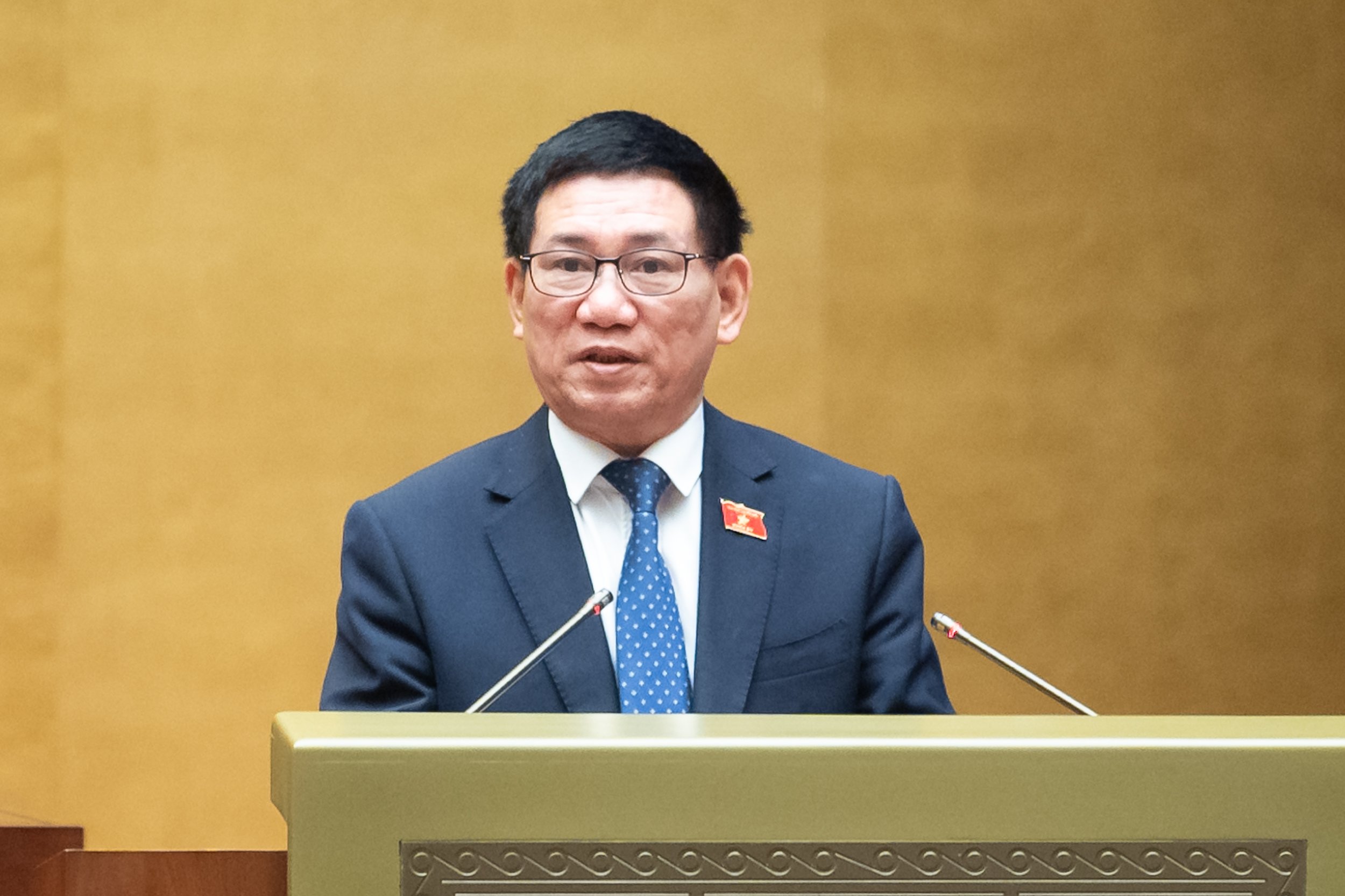 Bộ trưởng Bộ Tài chính Hồ Đức Phớc thừa ủy quyền của Thủ tướng Chính phủ trình bày Tờ trình. Ảnh: Quochoi.vn. 