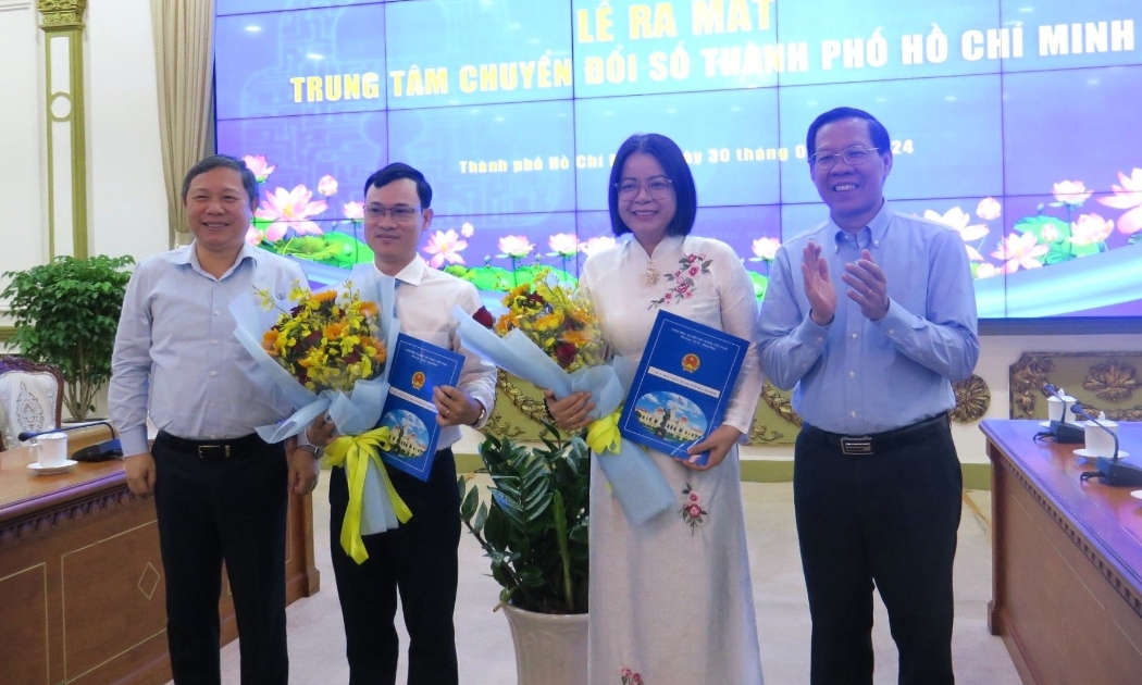 Chủ tịch UBND TP.HCM Phan Văn Mãi và Phó Chủ tịch UBND TP.HCM Dương Anh Đức trao quyết định và tặng hoa chúc mừng Tân Giám đốc và Phó Giám đốc Trung tâm Chuyển đổi số TP.HCM.