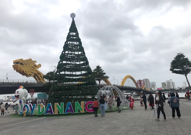 Khách du Xuân chụp ảnh lưu niệm tại Cầu Rồng. Ảnh Ngô Anh Văn