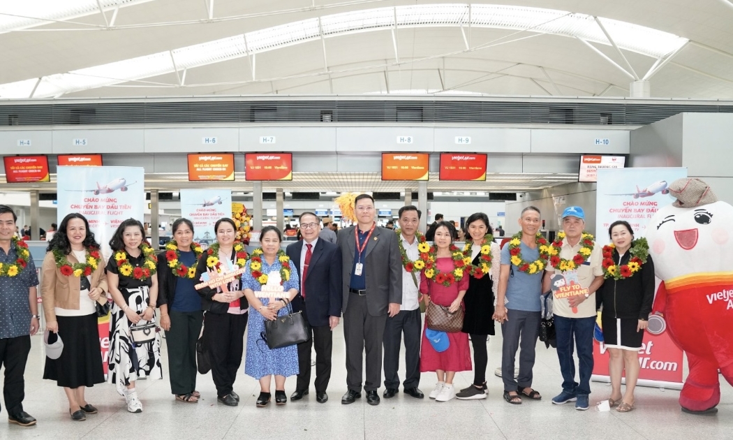 Phó Tổng lãnh sự Lào tại Tp.HCM, ông Souvannaseng Amphay cùng lãnh đạo Vietjet tặng hoa và chúc mừng những hành khách đầu tiên trên chuyến bay khai trương từ Tp.HCM đi Viêng Chăn, Lào.