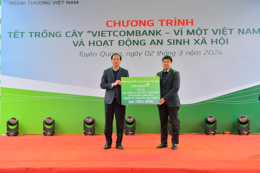 Đ/c H&ocirc;̀ng Quang - Ủy vi&ecirc;n BTV Đảng ủy, Thành vi&ecirc;n HĐQT, Chủ tịch C&ocirc;ng đoàn Vietcombank (b&ecirc;n phải) trao bi&ecirc;̉n tượng trưng kinh phí x&acirc;y dựng 10 căn nh&agrave; tình nghĩa cho đ/c Giang Tu&acirc;́n Anh - Chủ tịch UBND huyện Sơn Dương.