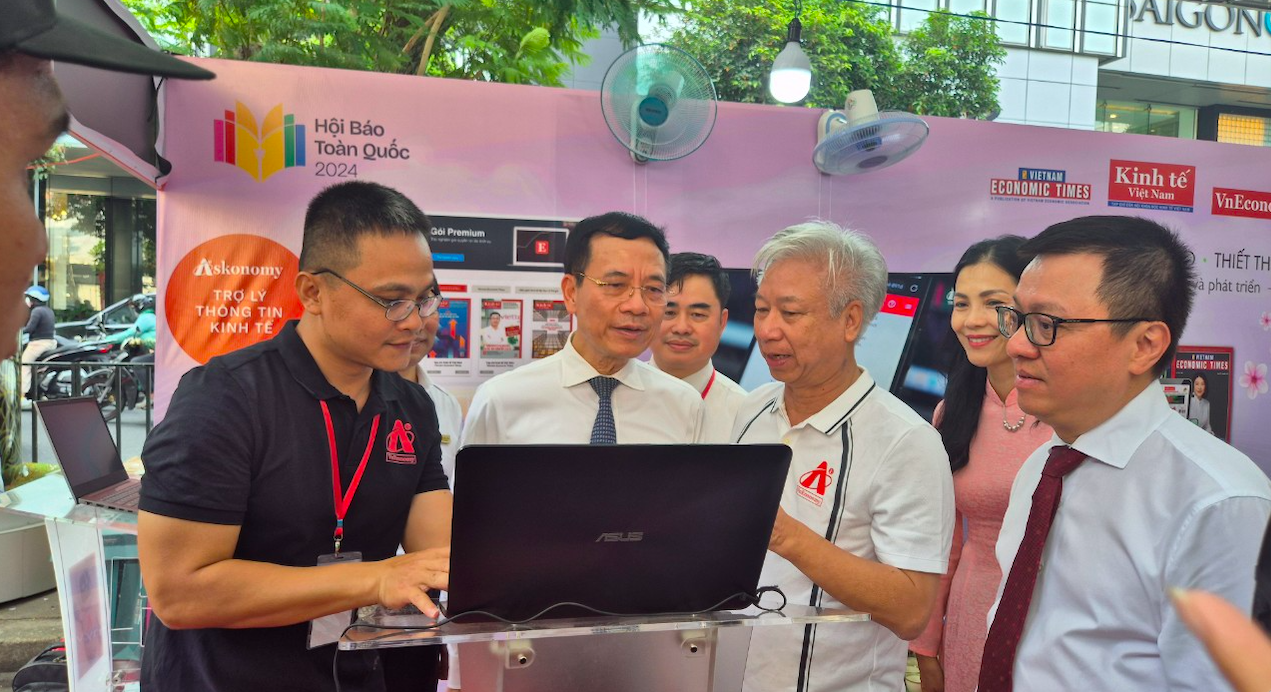 Bộ trưởng Bộ Thông tin và Truyền thông Nguyễn Mạnh Hùng (người thứ 2 từ trái sang) và Chủ tịch Hội Nhà báo Việt Nam Lê Quốc Minh (người đầu tiên bên phải) thăm gian hàng của Tạp chí Kinh tế Việt nam tại Hộ báo toàn quốc 2024. Nhà báo Đào Quang Bính, Tổng Thư ký Tạp chí Kinh tế Việt Nam/VnEconomy (người thứ 2 từ phải sang), giới thiệu Chatbot AI Askonomy  - Trợ lý thông tin kinh tế với Bộ trưởng và Chủ tịch Hội Nhà báo.