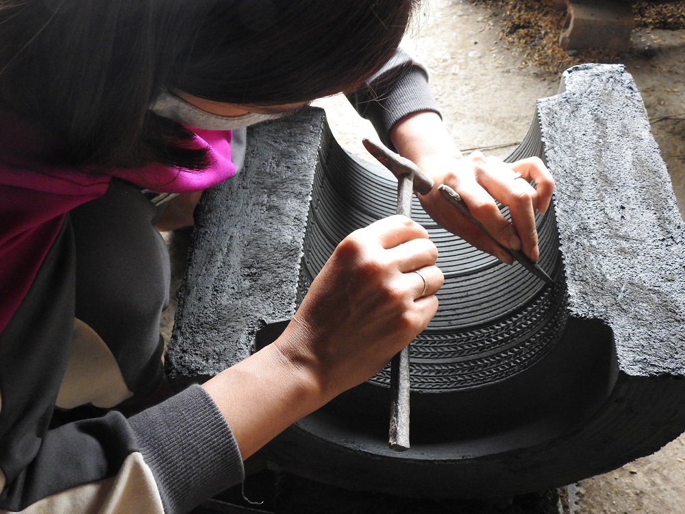 Nghệ nhân làng Trà Đông đang tạo hoa văn cho khuôn đúc.