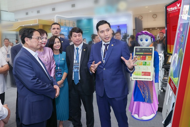 The PM listening to a presentation by a local bank's representative at the event. (Photo source: VGP.)
