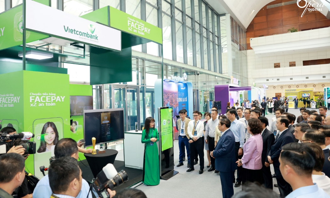 Bà Đoàn Hồng Nhung - Giám đốc Khối Bán lẻ Vietcombank giới thiệu về sản phẩm dịch vụ của Vietcombank với đoàn đại biểu do Thủ tướng Phạm Minh Chính (hàng đầu, thứ 2 từ phải sang) dẫn đầu tham quan trải nghiệm tại các gian hàng của sự kiện Chuyển đổi số ngành Ngân hàng năm 2024.