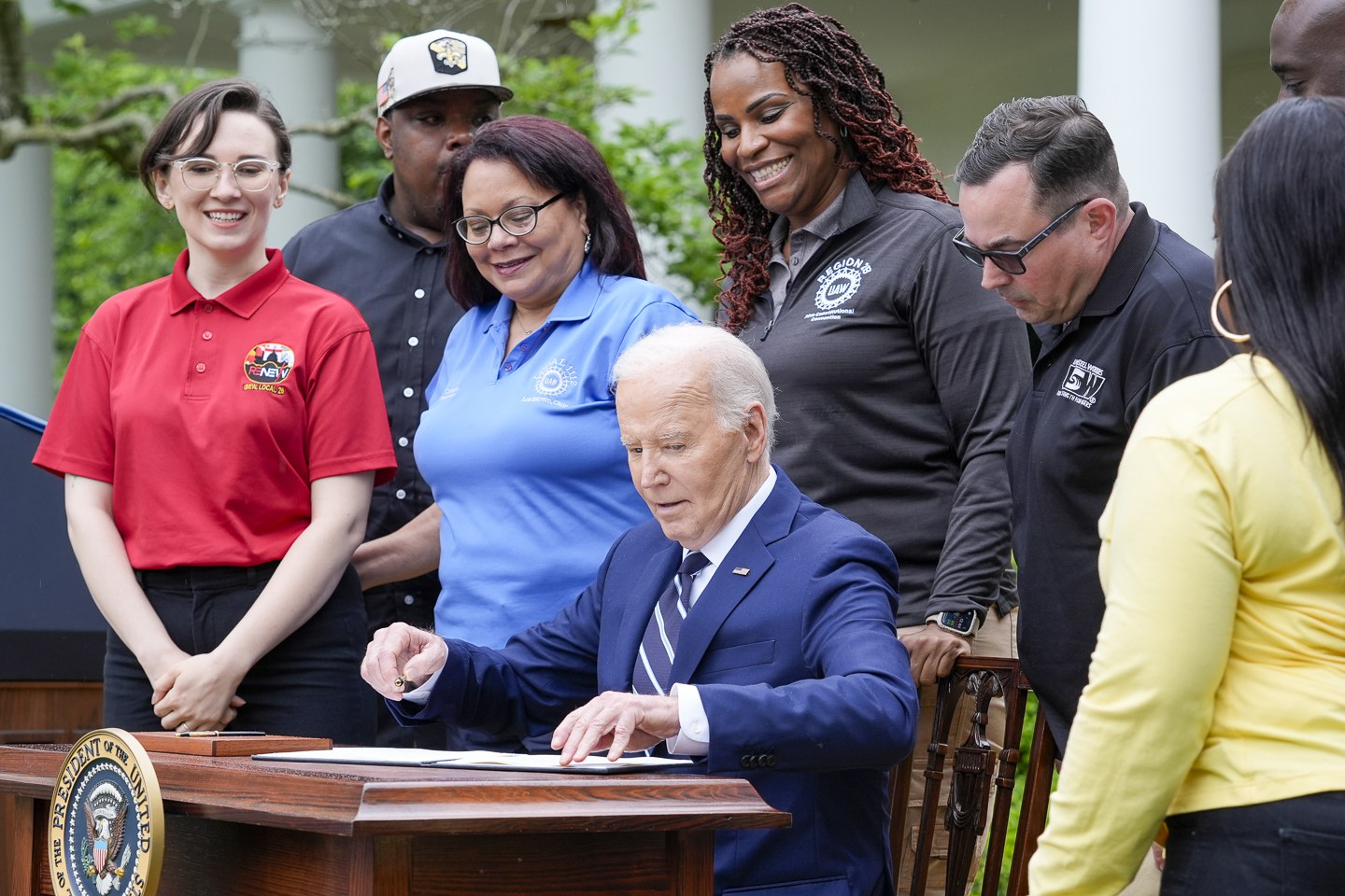 Tổng thống Mỹ Joe Biden đặt bút ký quyết định tăng thuế với một loạt hàng hóa Trung Quốc tại Vườn Hồng, Nhà Trắng ngày 14/5 - Ảnh: AP