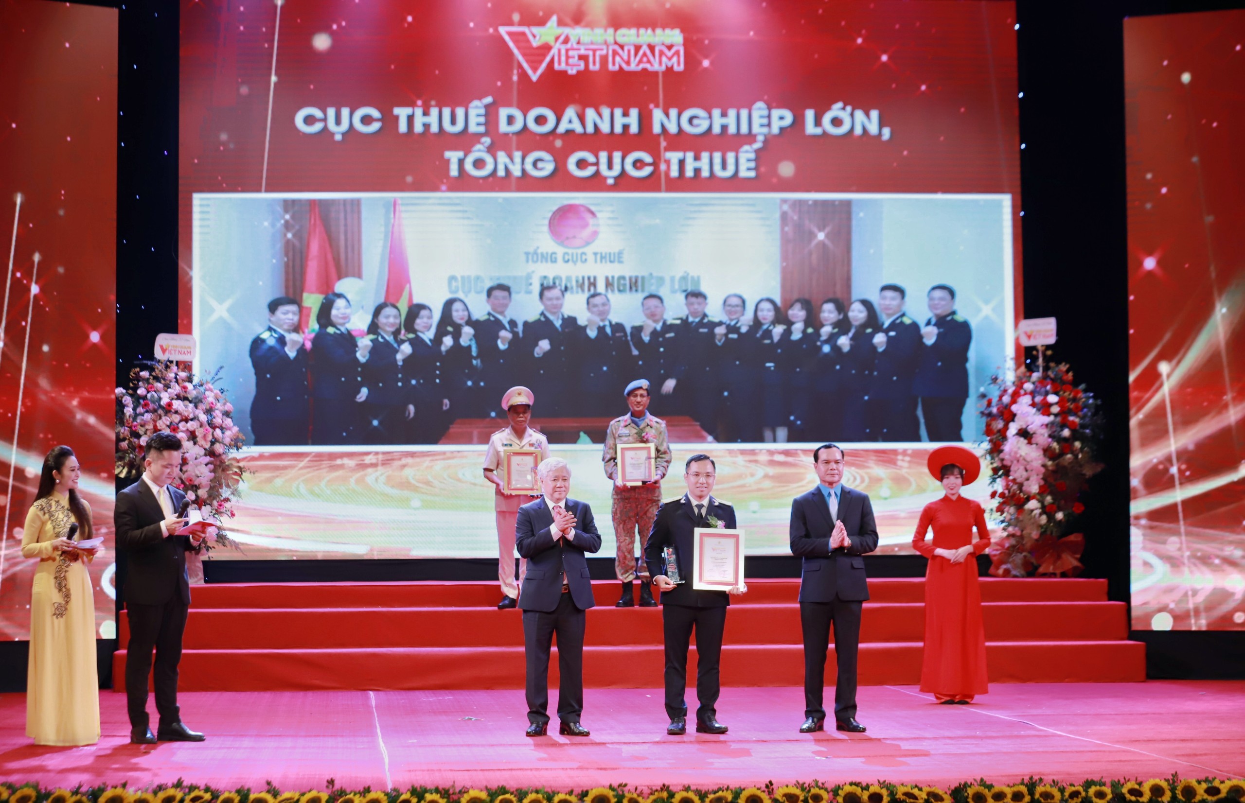 Ông Đỗ Văn Chiến và ông Nguyễn Đình Khang trao biểu trưng và bằng khen cho Cục Thuế Doanh nghiệp lớn – Tổng cục Thuế. Ảnh: Tô Thế.