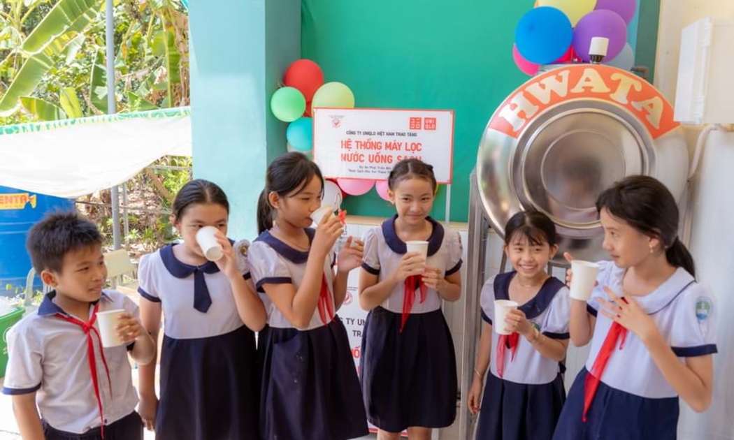 Học sinh trường tiểu học Thạnh An bên hệ thống lọc nước sạch mới.