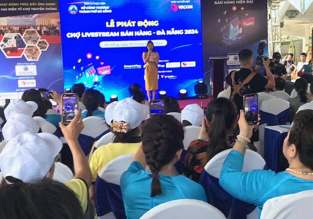 Các tiểu thương chợ Cồn thực hiện Livestream tại Lễ phát động. Ảnh Ngô Anh Văn